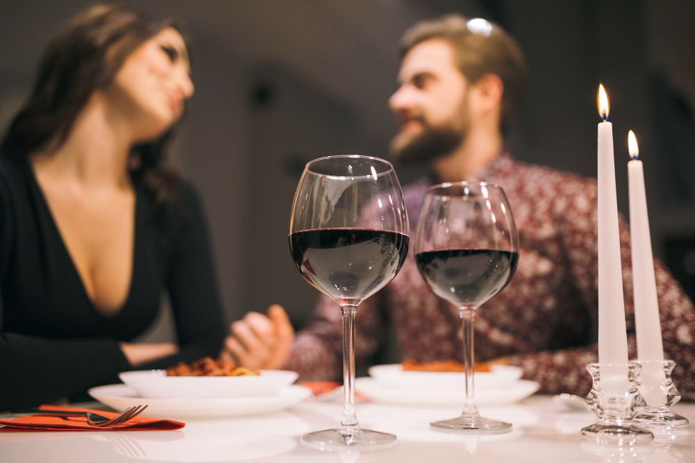 A couple sharing dinner and wine by candlelight