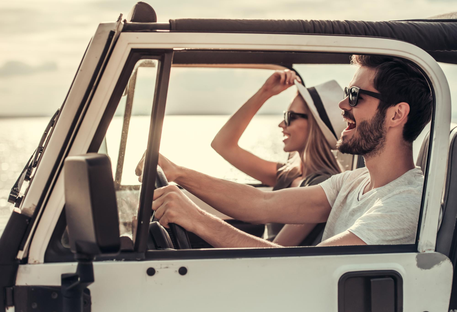A couple enjoying a drive together by the water