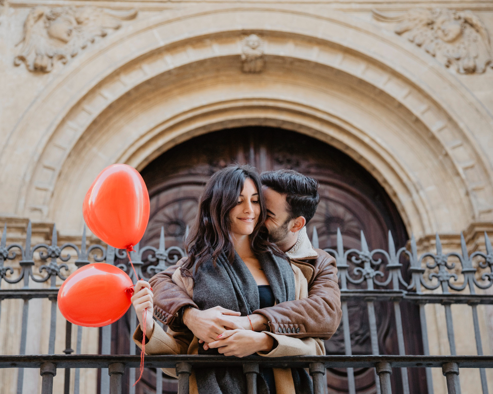 Vancouver couple sharing an affectionate moment near historic architecture